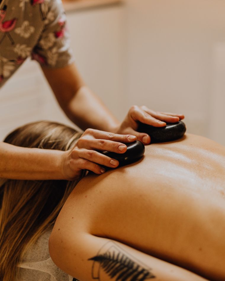 Masérka při masáži zad lávovými kameny v Sumai Spa Turnov